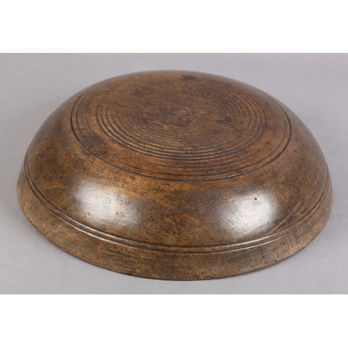 75 - A 19TH CENTURY TURNED FRUIT WOOD DAIRY BOWL, with moulded rim and simple incised line decoration, 35... 