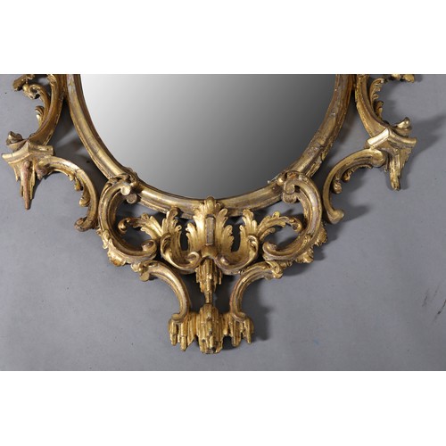 497 - A GEORGE II GILTWOOD AND GESSO WALL MIRROR IN THE MANNER OF THOMAS CHIPPENDALE, c1718-1779, the oval... 