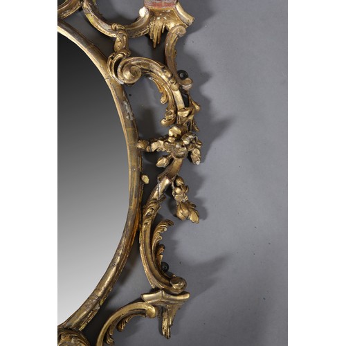 497 - A GEORGE II GILTWOOD AND GESSO WALL MIRROR IN THE MANNER OF THOMAS CHIPPENDALE, c1718-1779, the oval... 