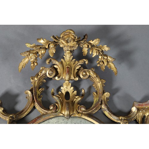 497 - A GEORGE II GILTWOOD AND GESSO WALL MIRROR IN THE MANNER OF THOMAS CHIPPENDALE, c1718-1779, the oval... 