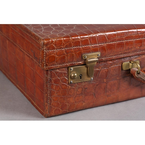 27 - FINNEGAN OF BOND STREET, LONDON, An early 20th century crocodile skin suitcase with moire silk linin... 