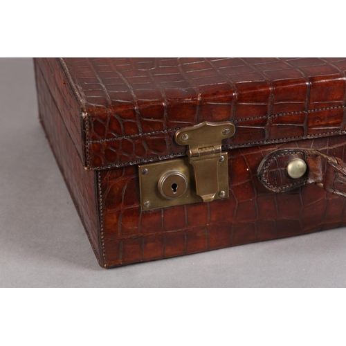 28 - NORTH WEST TANNERS COMPANY, CAWNPORE, late 19th/early 20th century crocodile skin suitcase, lined in... 