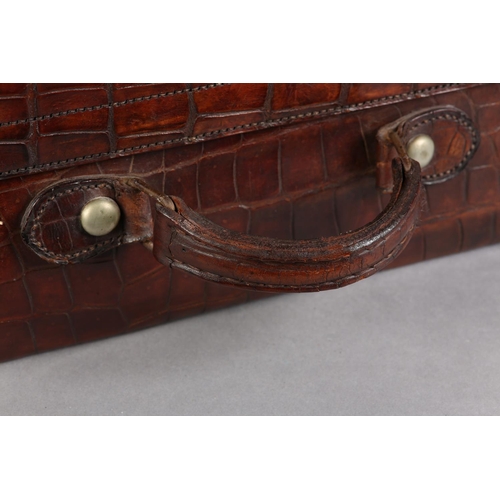 28 - NORTH WEST TANNERS COMPANY, CAWNPORE, late 19th/early 20th century crocodile skin suitcase, lined in... 