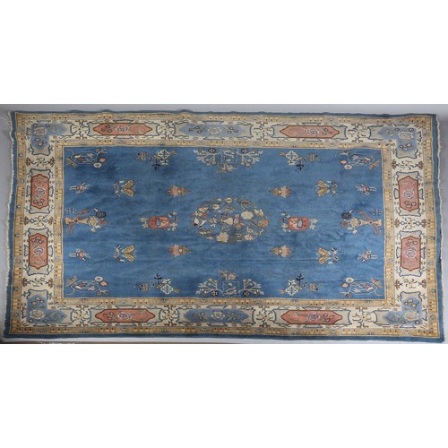 491 - AN ART DECO CHINOISSERIE CARPET, the blue field worked with plant forms, pagodas, butterflies, the p... 