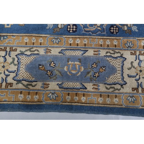 491 - AN ART DECO CHINOISSERIE CARPET, the blue field worked with plant forms, pagodas, butterflies, the p... 