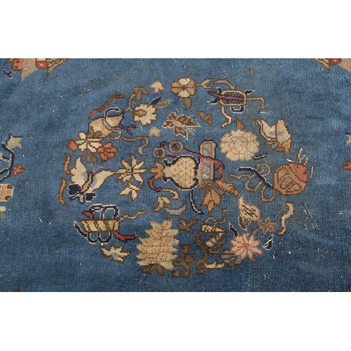 491 - AN ART DECO CHINOISSERIE CARPET, the blue field worked with plant forms, pagodas, butterflies, the p... 