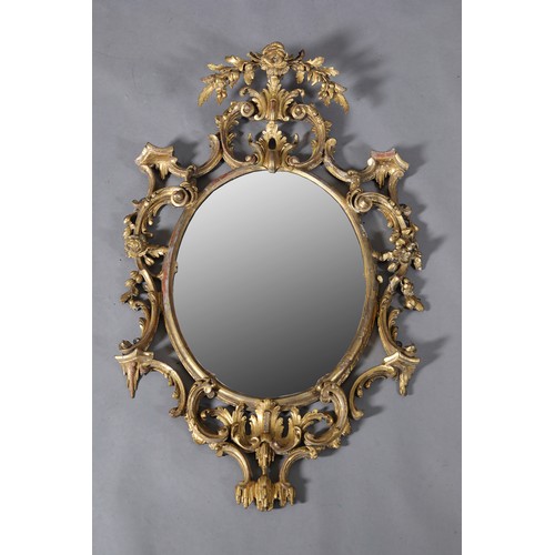 287 - A GEORGE II GILTWOOD AND GESSO WALL MIRROR IN THE MANNER OF THOMAS CHIPPENDALE, c1718-1779, the oval...