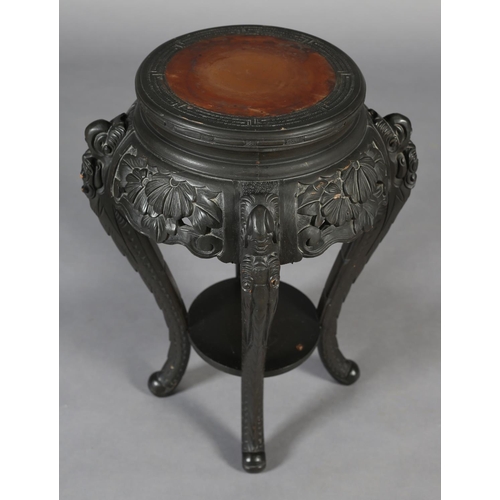 283 - A CHINESE CARVED WOOD URN STAND, circular with pierced foliate apron, on four serpentine legs joined... 
