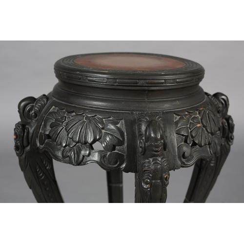 283 - A CHINESE CARVED WOOD URN STAND, circular with pierced foliate apron, on four serpentine legs joined... 