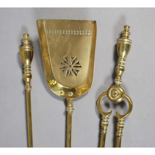 58 - A SET OF THREE VICTORIAN BRASS FIREIRONS with urn shaped terminals comprising poker, shovel and pair... 
