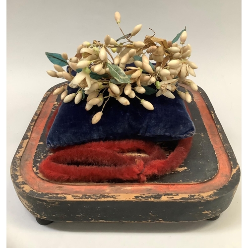 27 - A Victorian bride's wax and silk headdress displayed on a blue velvet cushion beneath a glass dome o... 