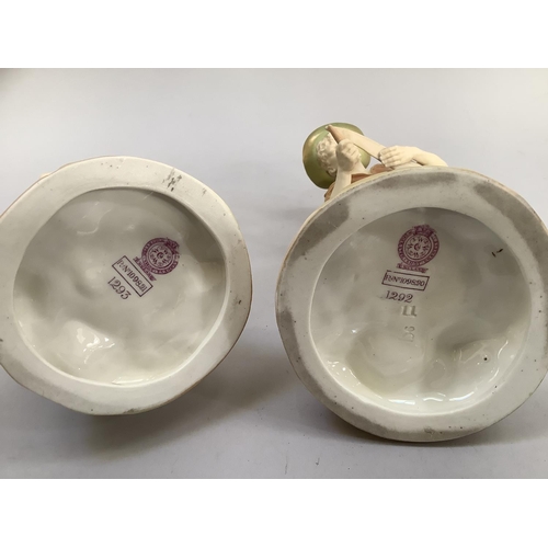5 - A pair of Royal Worcester blush ivory and pale green gilded figures of a girl holding a nest of bird... 