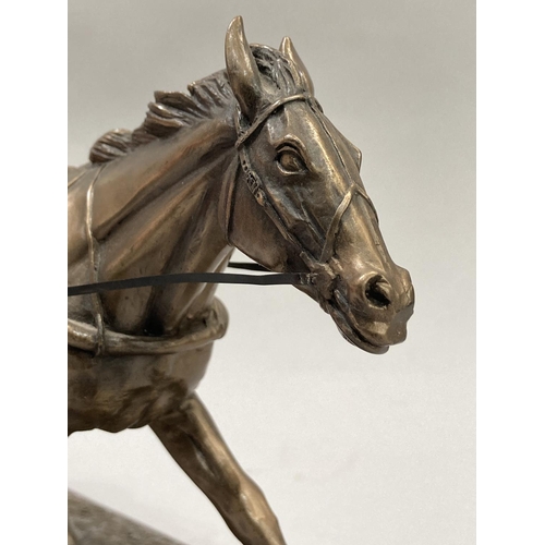 35 - A bronzed effect resin model of a trotting horse and sulky with driver, 39cm long x 15.5cm high appr... 