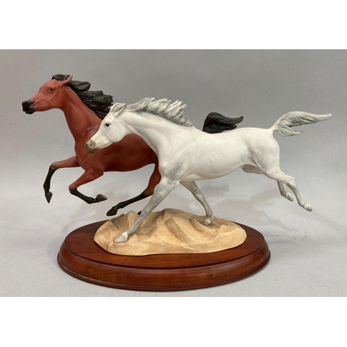 36 - A pair of stallions in full gallop, ceramic by Franklin Mint on wooden base. 42cm long x 26cm high a... 