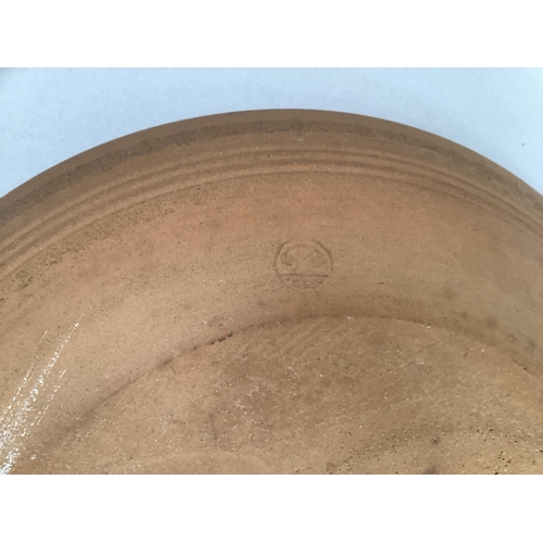 27 - Studio earthware plaque with slip decoration, impressed potter's mark to underside, 32cm diameter