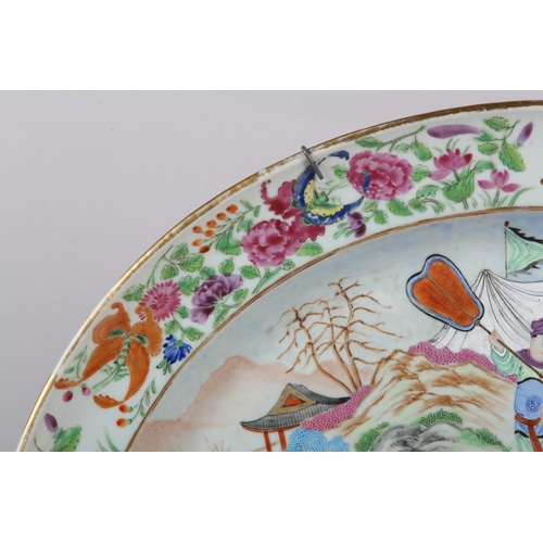 124 - A CHINESE CANTON FAMILLE ROSE CHARGER of oval outline, enamelled with a battle scene, warriors on ho... 