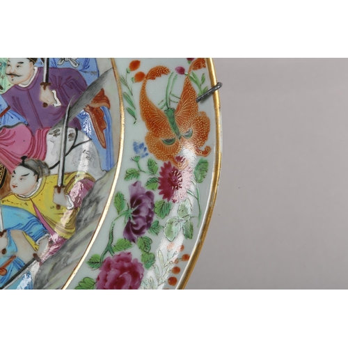 124 - A CHINESE CANTON FAMILLE ROSE CHARGER of oval outline, enamelled with a battle scene, warriors on ho... 