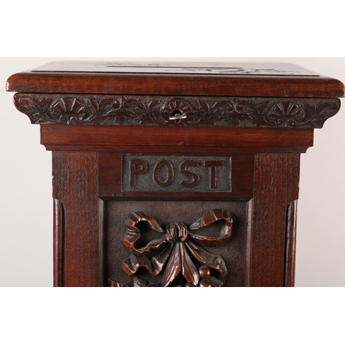 32 - A VICTORIAN STYLE OAK COUNTRY HOUSE LETTER BOX, of square outline, the hinged lid with slot, the fro... 