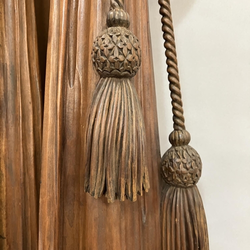 A pair of carved wooden ribboned and tasselled swags with flowering ...