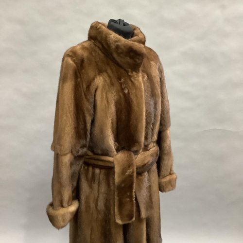 282 - A long length mink coat with stand-up collar and belt, Size 8 approximately