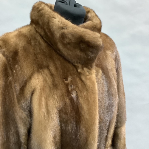 282 - A long length mink coat with stand-up collar and belt, Size 8 approximately
