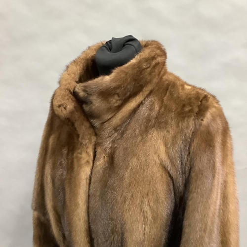 282 - A long length mink coat with stand-up collar and belt, Size 8 approximately