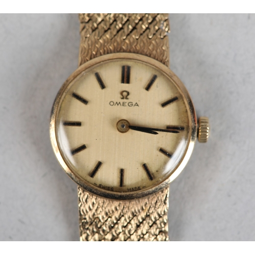 336 - AN OMEGA LADY'S MANUAL WRISTWATCH in 9ct gold on an integral textured Milanese bracelet in 9ct gold,... 