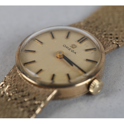 336 - AN OMEGA LADY'S MANUAL WRISTWATCH in 9ct gold on an integral textured Milanese bracelet in 9ct gold,... 