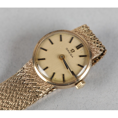 336 - AN OMEGA LADY'S MANUAL WRISTWATCH in 9ct gold on an integral textured Milanese bracelet in 9ct gold,... 