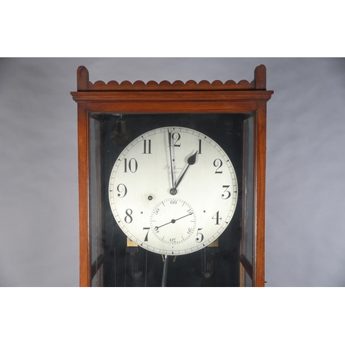 69 - AN EARLY 20TH CENTURY WALNUT AND GLAZED REGULATOR, signed F. C. Moore of Leeds, having a silvered di... 