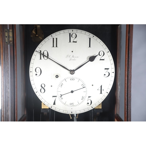 69 - AN EARLY 20TH CENTURY WALNUT AND GLAZED REGULATOR, signed F. C. Moore of Leeds, having a silvered di... 