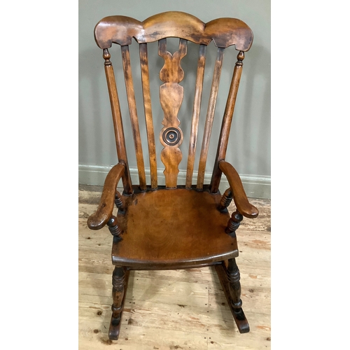 A nineteenth century beech rocking chair having a triple-arch top rail ...
