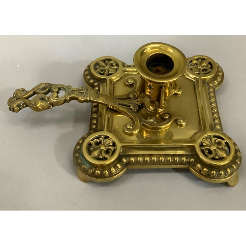 43 - A Victorian brass chamber stick with pierced handle of square outline with rounded corners and beade... 