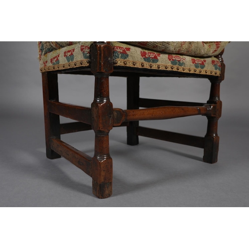 272 - A LATE 17TH CENTURY YEW-WOOD OPEN ARMCHAIR, the high back and cushioned seat upholstered in rug fabr... 