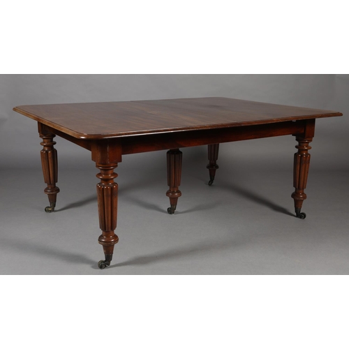 285 - A VICTORIAN MAHOGANY EXTENDING DINING TABLE, with five leaves, on five reeded and turned legs with b... 