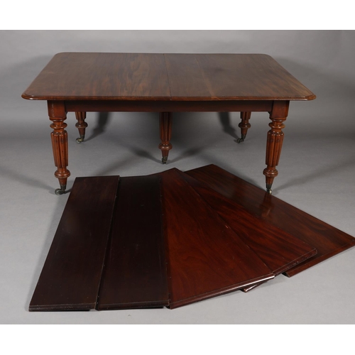 285 - A VICTORIAN MAHOGANY EXTENDING DINING TABLE, with five leaves, on five reeded and turned legs with b... 