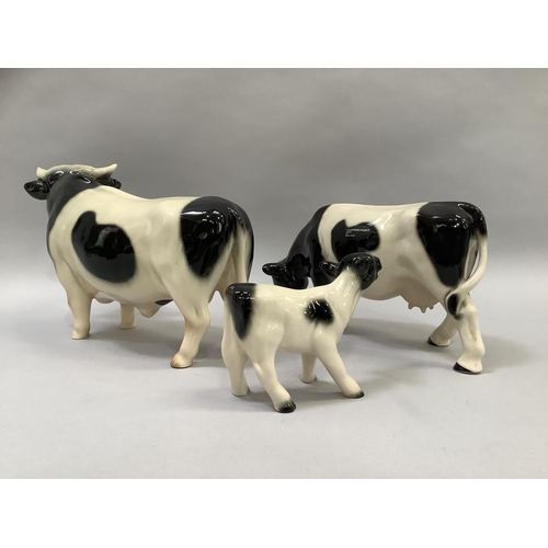 36 - A Coopercraft Freisian bull, heifer and calf group, still with labels, the bull measuring 16cm high