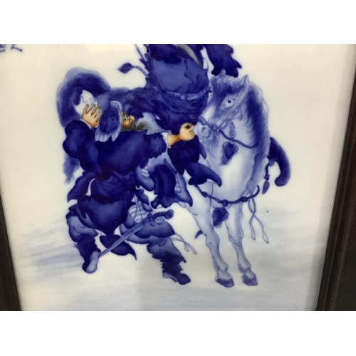 24 - A modern Chinese tile painted in blue and white highlighted in ochre depicting a horseman and swords... 
