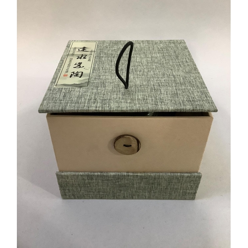 25 - A small celadon glaze earthenware pot with incised scroll decoration to the shoulder and stiff leaf ... 