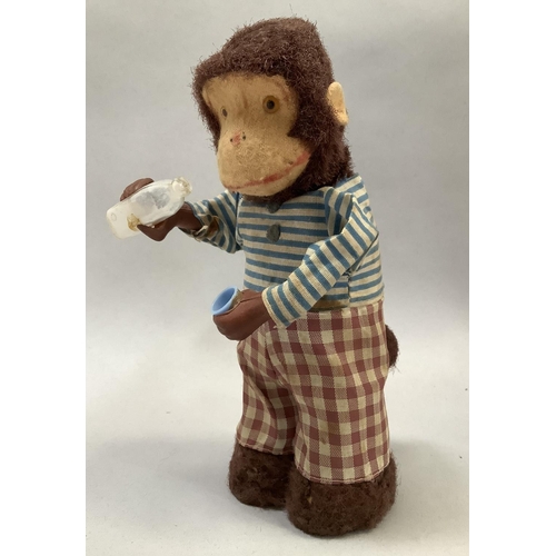 10 - An Alps Japan clockwork Thirsty Monkey, pouring milk from a bottle to a glass and drinking, 17cm hig... 