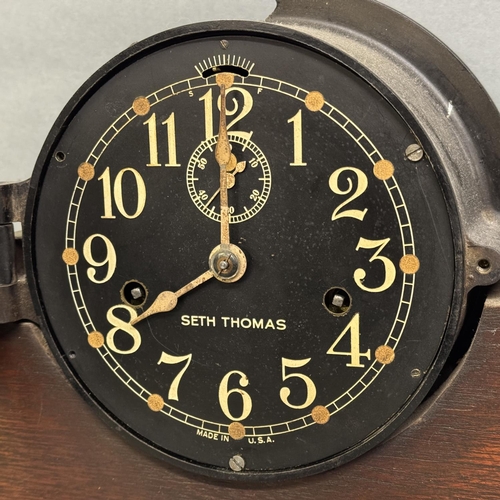 137 - A mid-century Seth Thomas Deck Clock with white numbers on a black face in a Bakelite case with knur... 