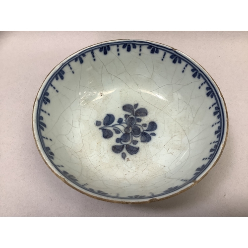 322 - A tin glaze bowl painted with flowers to the exterior and well on deep foot rim, measuring 12.75cm d... 