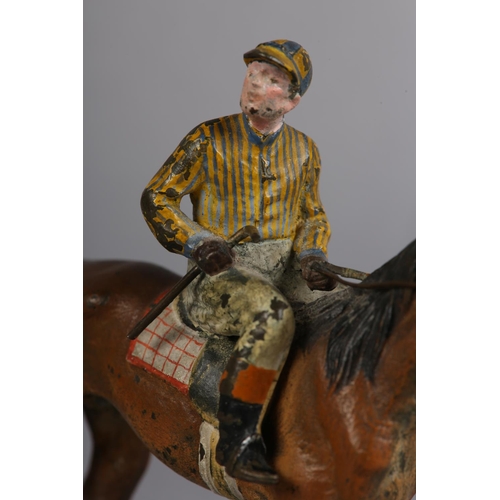 60 - AN EARLY 20TH CENTURY COLD PAINTED BRONZE MODEL OF A RACE HORSE with jockey up, 11cm high