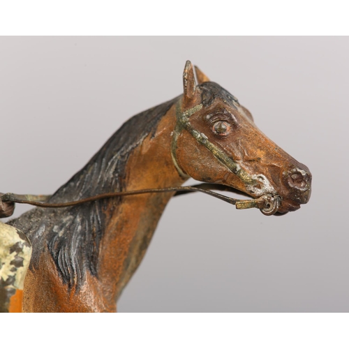 60 - AN EARLY 20TH CENTURY COLD PAINTED BRONZE MODEL OF A RACE HORSE with jockey up, 11cm high