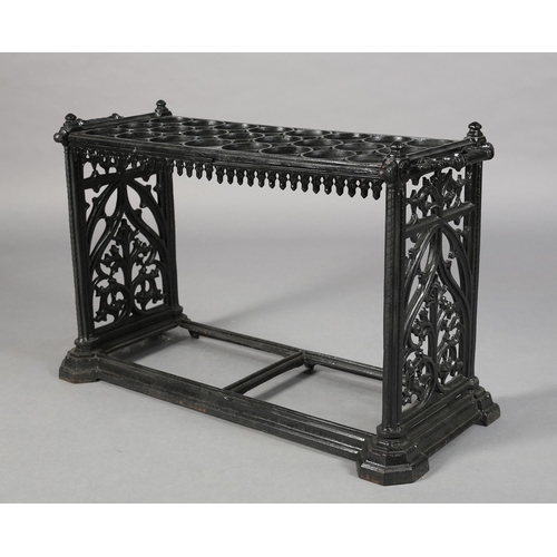 27 - A MID VICTORIAN CAST IRON STICK STAND, having eight rows of three circular rings, above a pendant ap... 