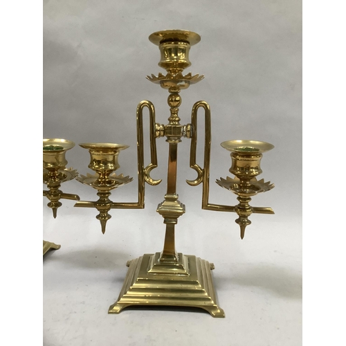 51 - A pair of Victorian brass three light candle sticks each on square stepped base with bracket feet, 2... 