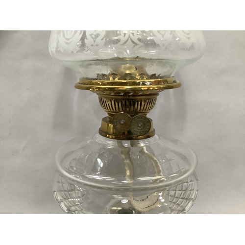 43 - A Victorian brass table lamp with cut glass reservoir, etched shade with deeply wavy rim and on a bl... 