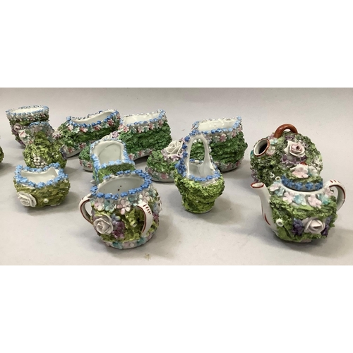 38 - A collection of Victorian Elfin or Moss ware including a pair of boots, a slipper, miniature vases, ... 