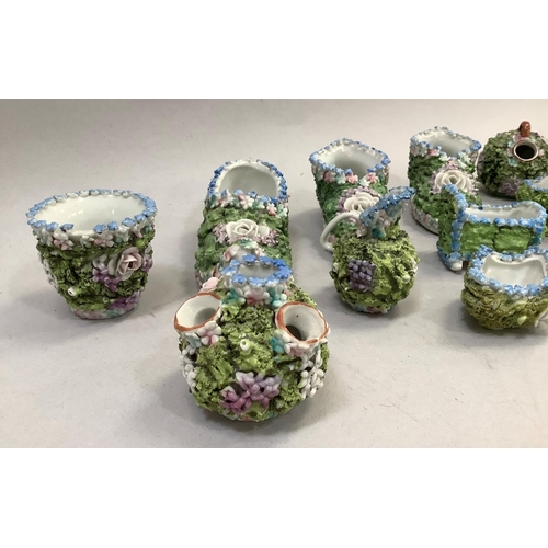 38 - A collection of Victorian Elfin or Moss ware including a pair of boots, a slipper, miniature vases, ... 