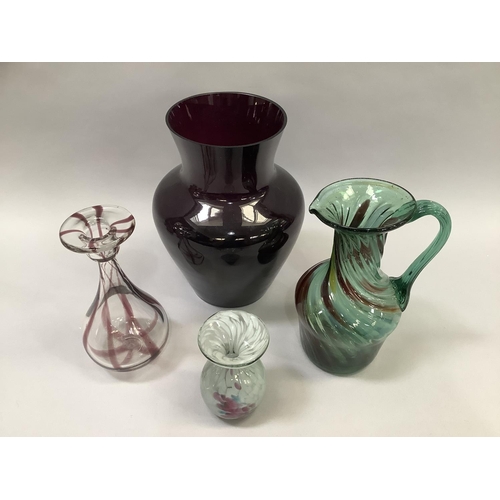 15 - Four items of art glass including a green glass jug of writhen moulding streaked with yellow, burgun... 